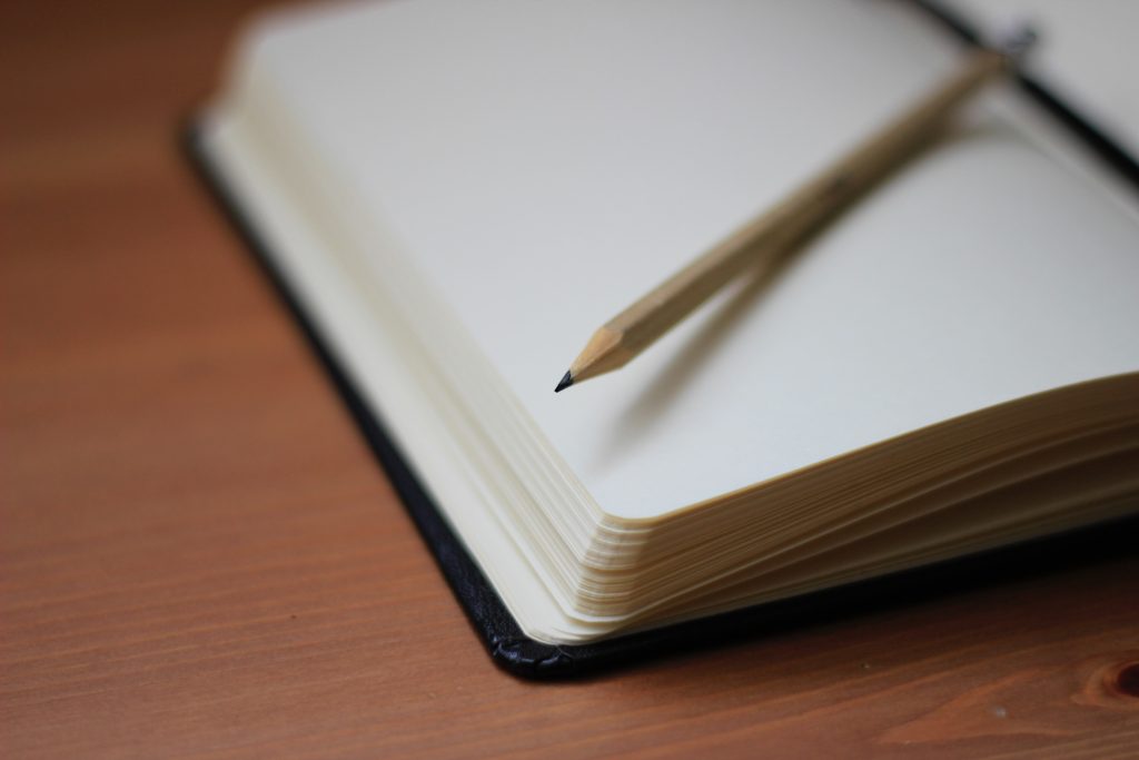 Sổ tay mở và bút chì trên bàn làm việc
